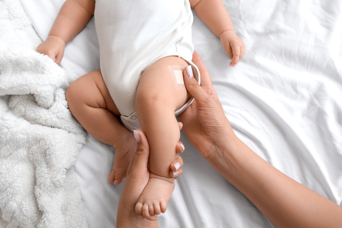 Baby krijgt een pleister op de bovenbeen na een vaccinatie