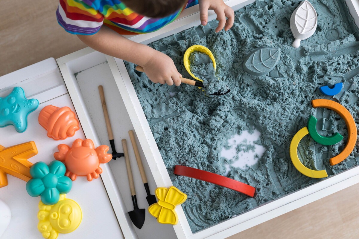 Kind speelt aan een tafel met speelzand
