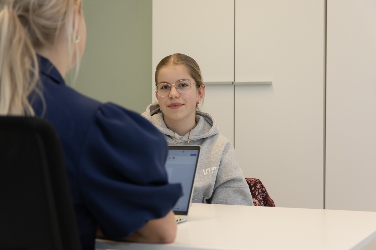 Tiener in gesprek met een jeugdverpleegkundige op school