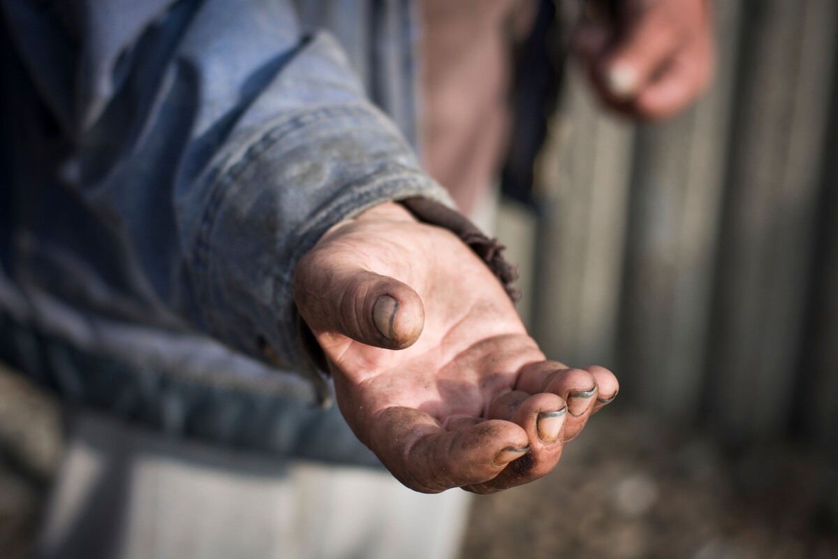 Hand van iemand die bedelt om eten of geld
