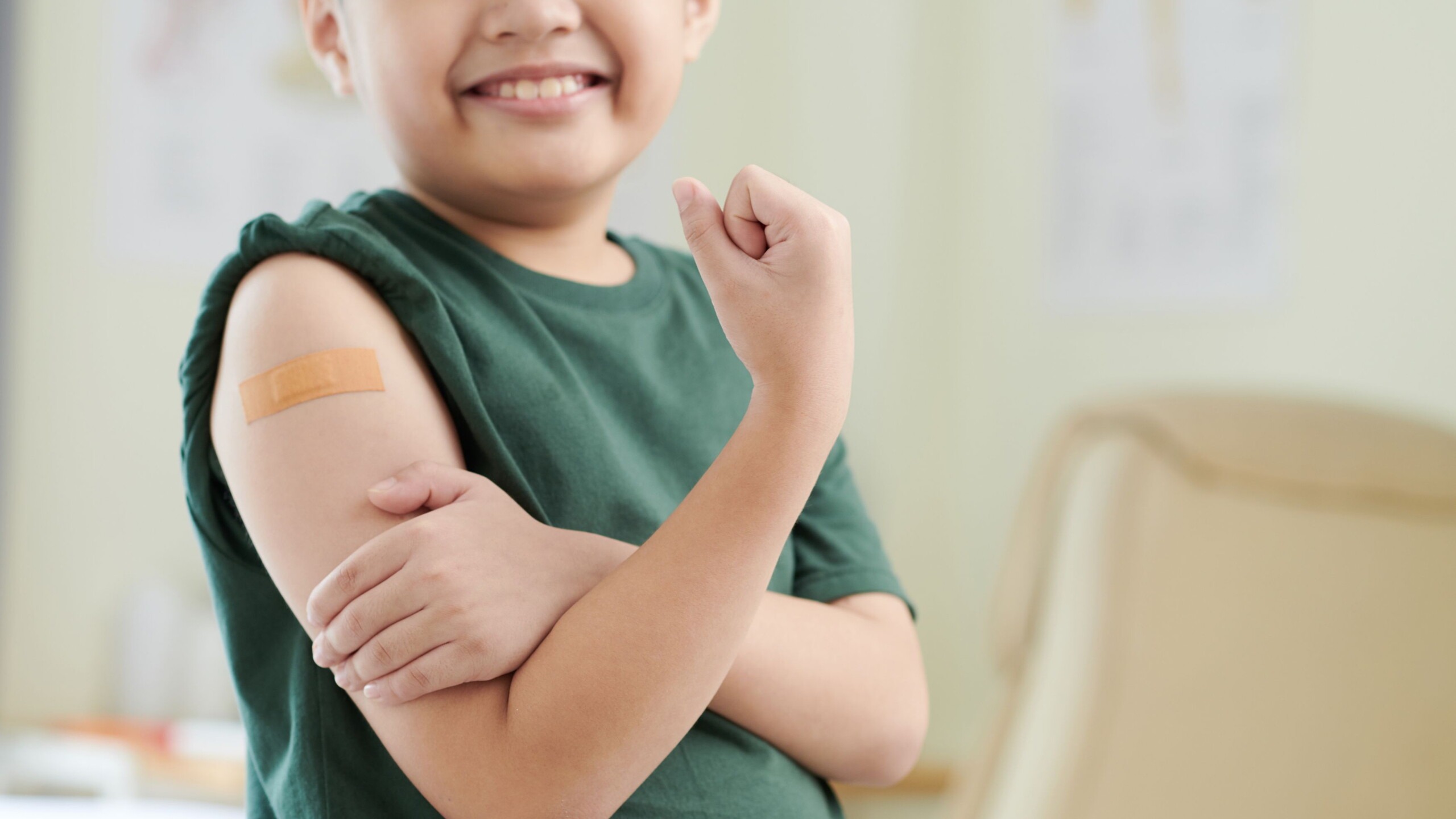Jongen met een pleister op zijn arm na het krijgen van een vaccinatie