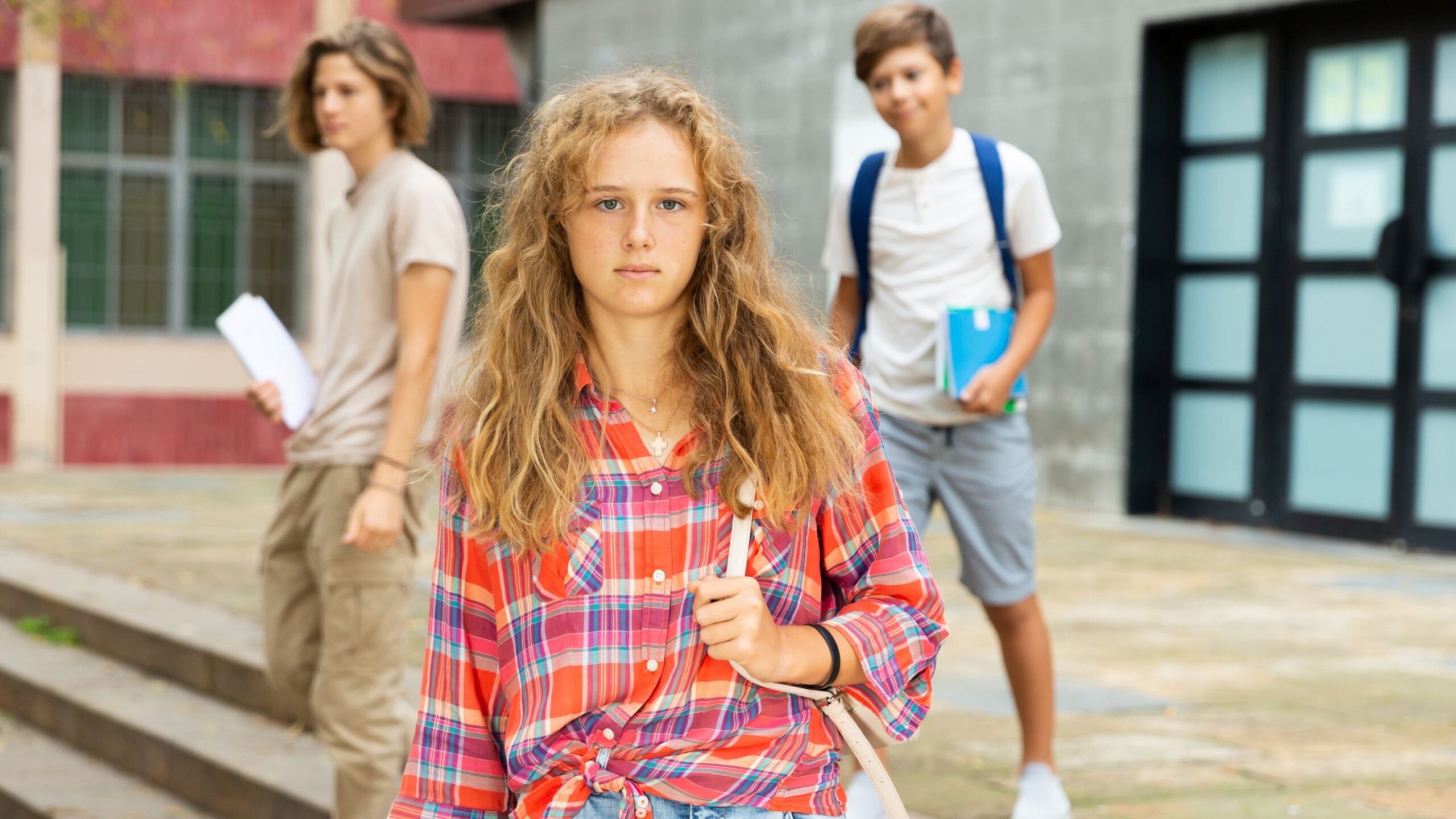 Drie jongeren op het schoolplein