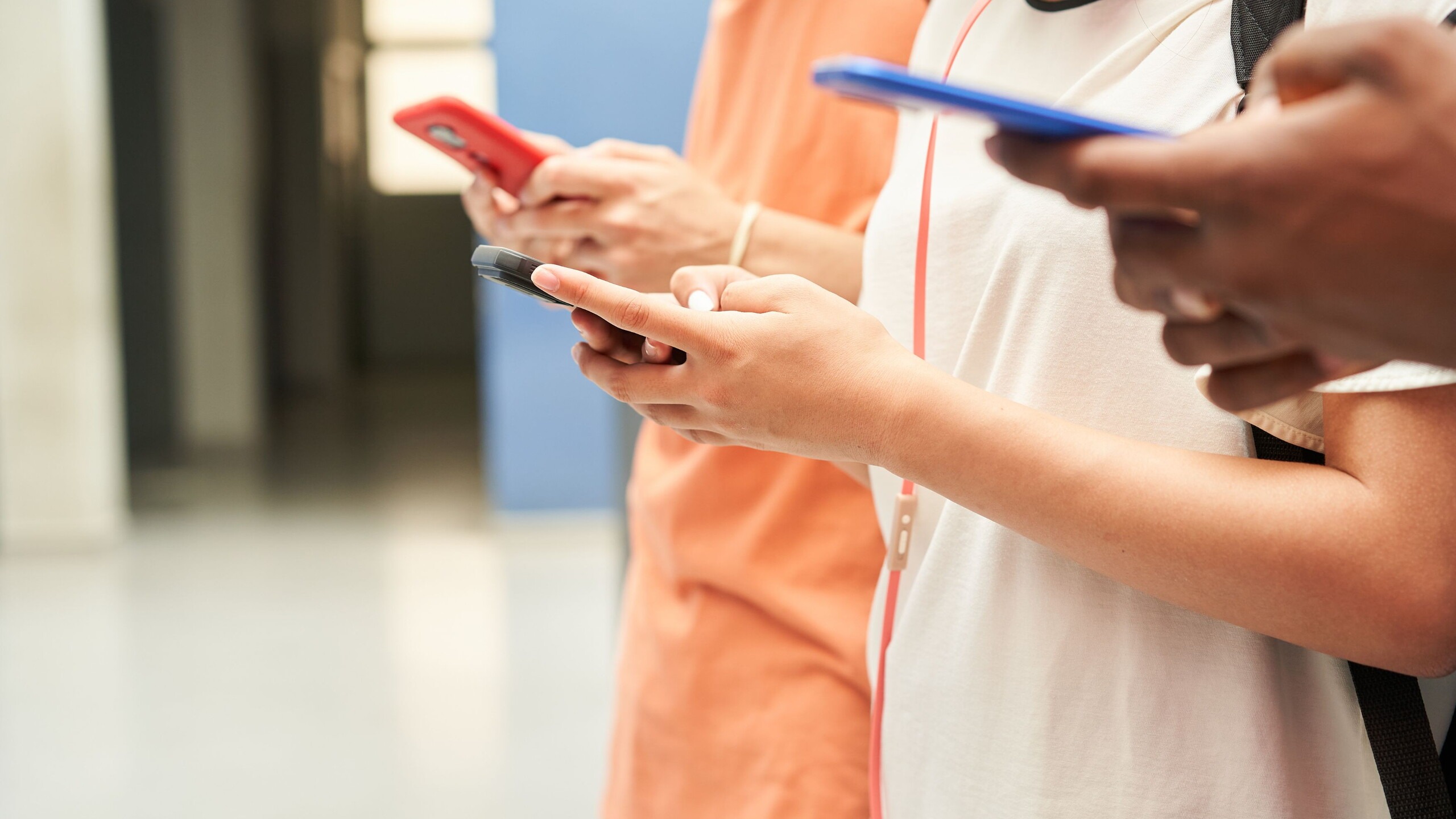 Tieners met hun telefoon in de hand op school