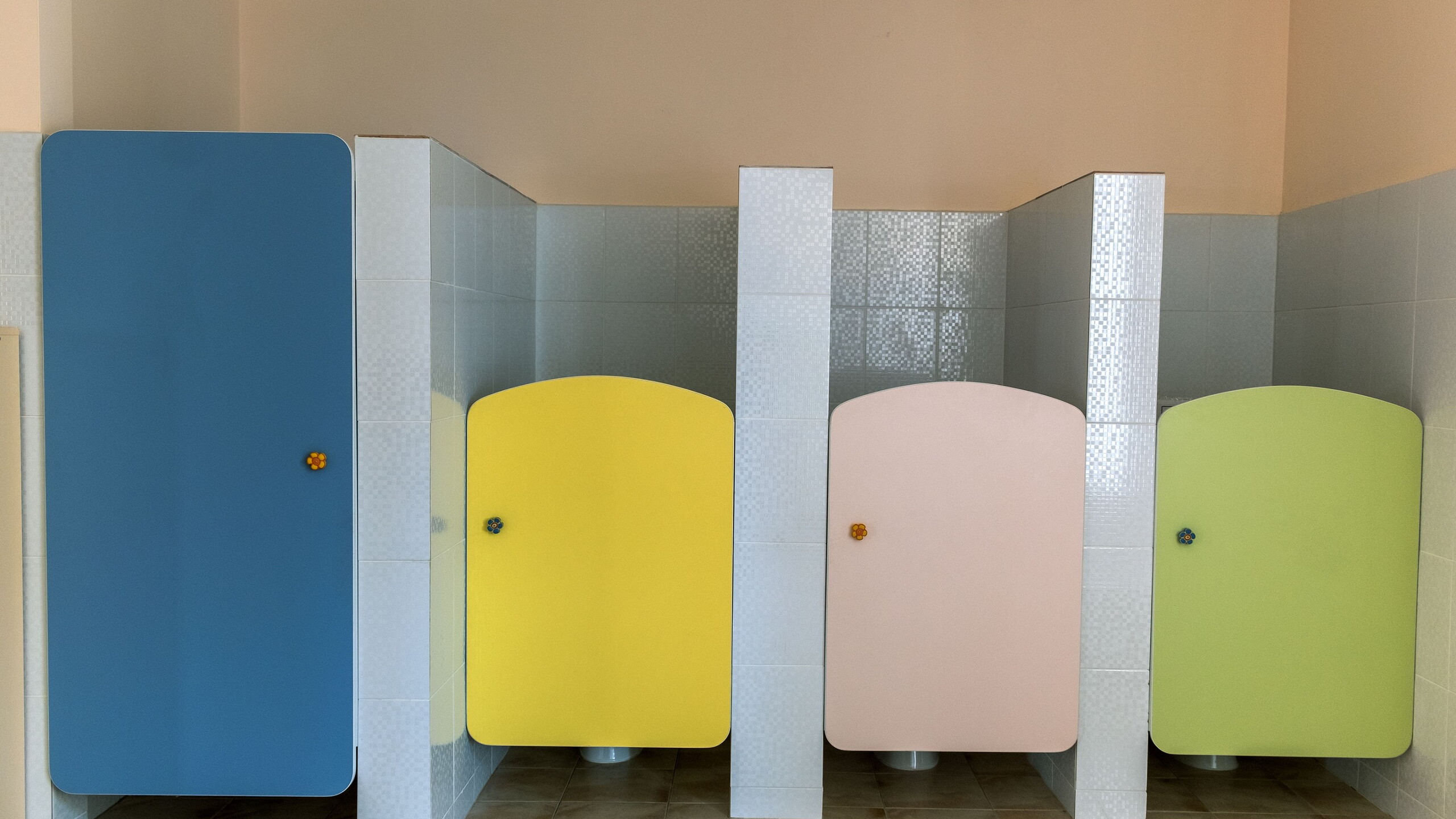 WC's op een basisschool. Kleurrijke WC-deuren