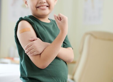 Jongen met een pleister op zijn arm na het krijgen van een vaccinatie