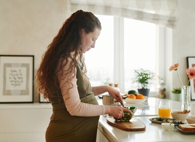 Zwangere vrouw is eten aan het klaarmaken