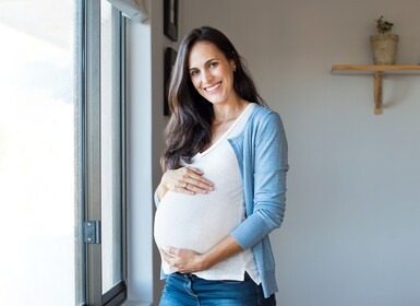 Vrouw die zwanger is en haar buik vasthoudt